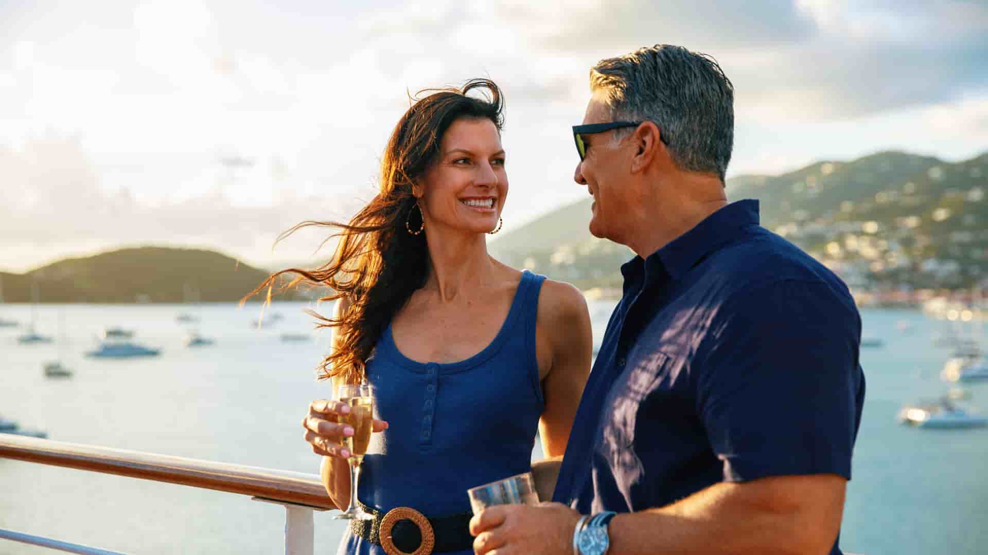 A couple happily enjoying a glass of wine onboard an Azamara cruise in the Caribbean.