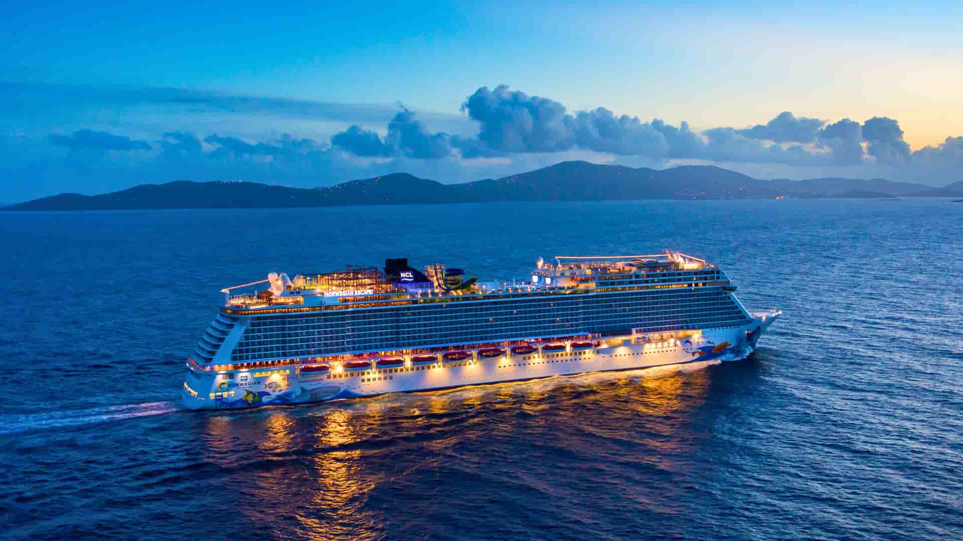 The Norwegian Escape cruise ship is shown at dusk, sailing away from the island of St. Thomas in the U.S. Virgin Islands, a popular port of call in the Caribbean.