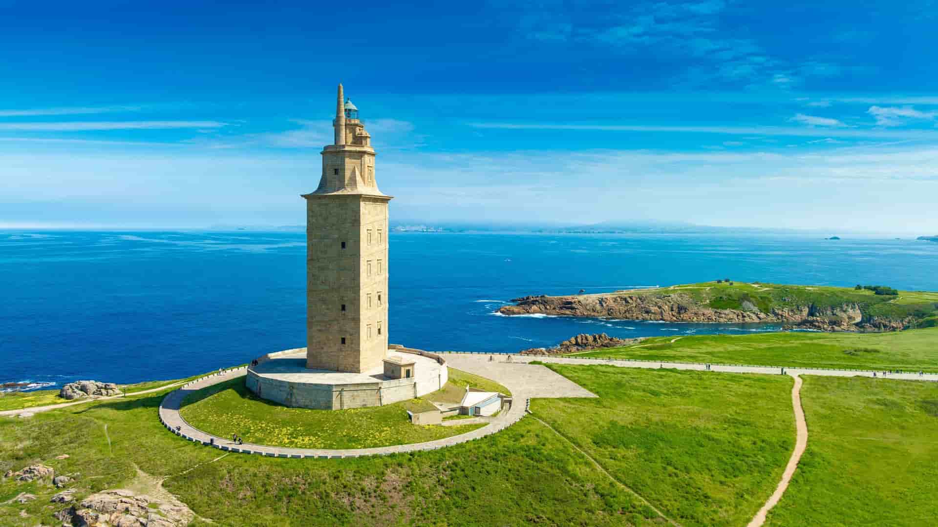 An aerial view of the historic Tower of Hercules, a UNESCO World Heritage site and the oldest Roman lighthouse, situated on a grassy peninsula overlooking the Atlantic Ocean in La Coruna, Spain.