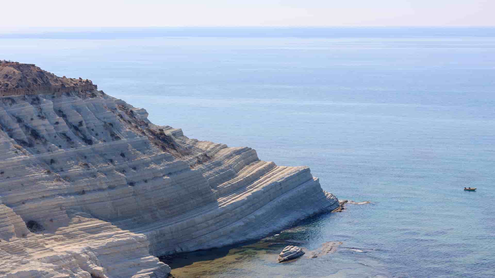 A stunning close-up of the Scala dei Turchi white marl cliff near Porto Empedocle, Sicily, jutting out into the crystal-clear turquoise Mediterranean Sea.