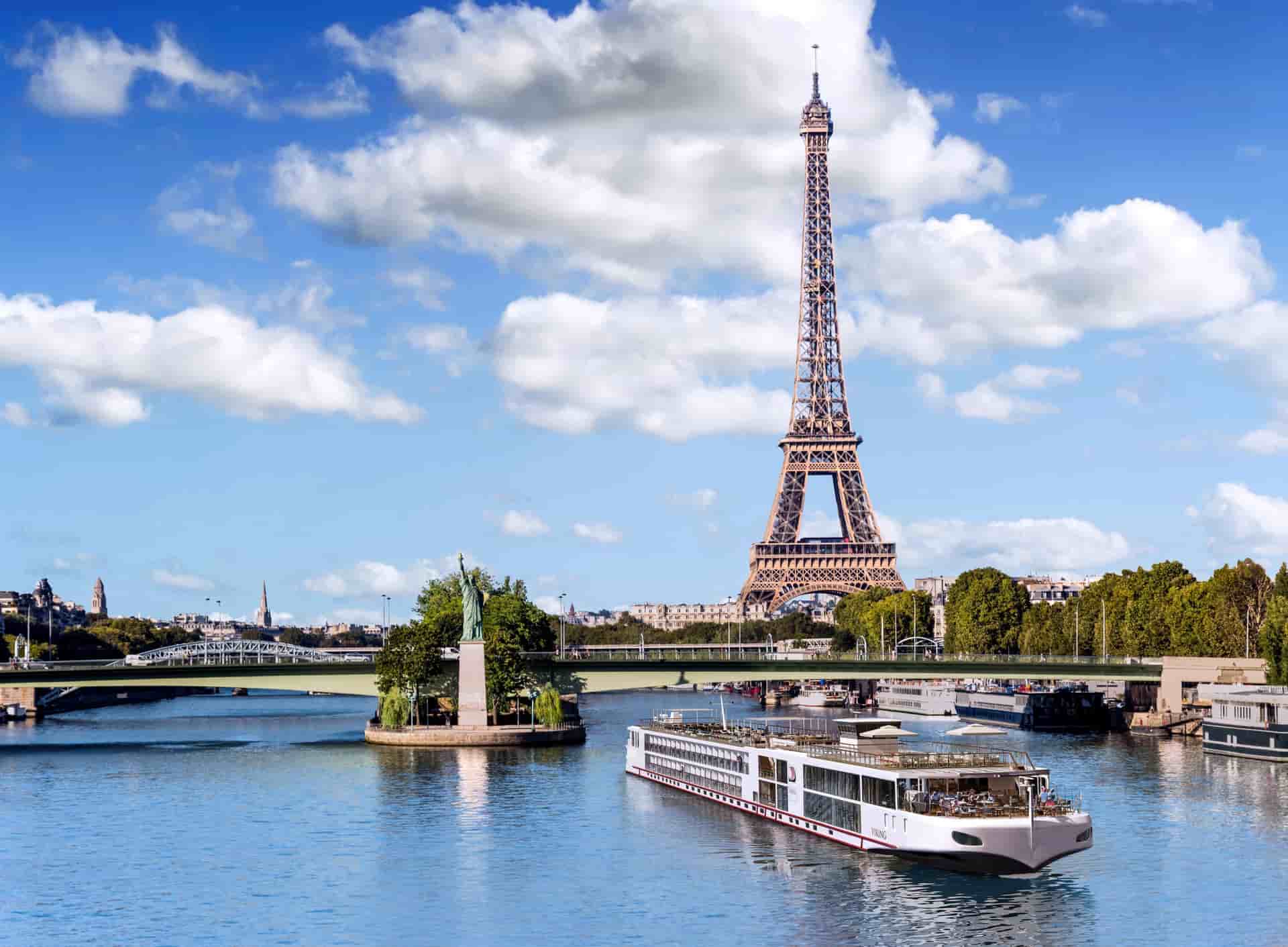 A sleek Viking River long ship sailing with the Eiffel Tower in the background.