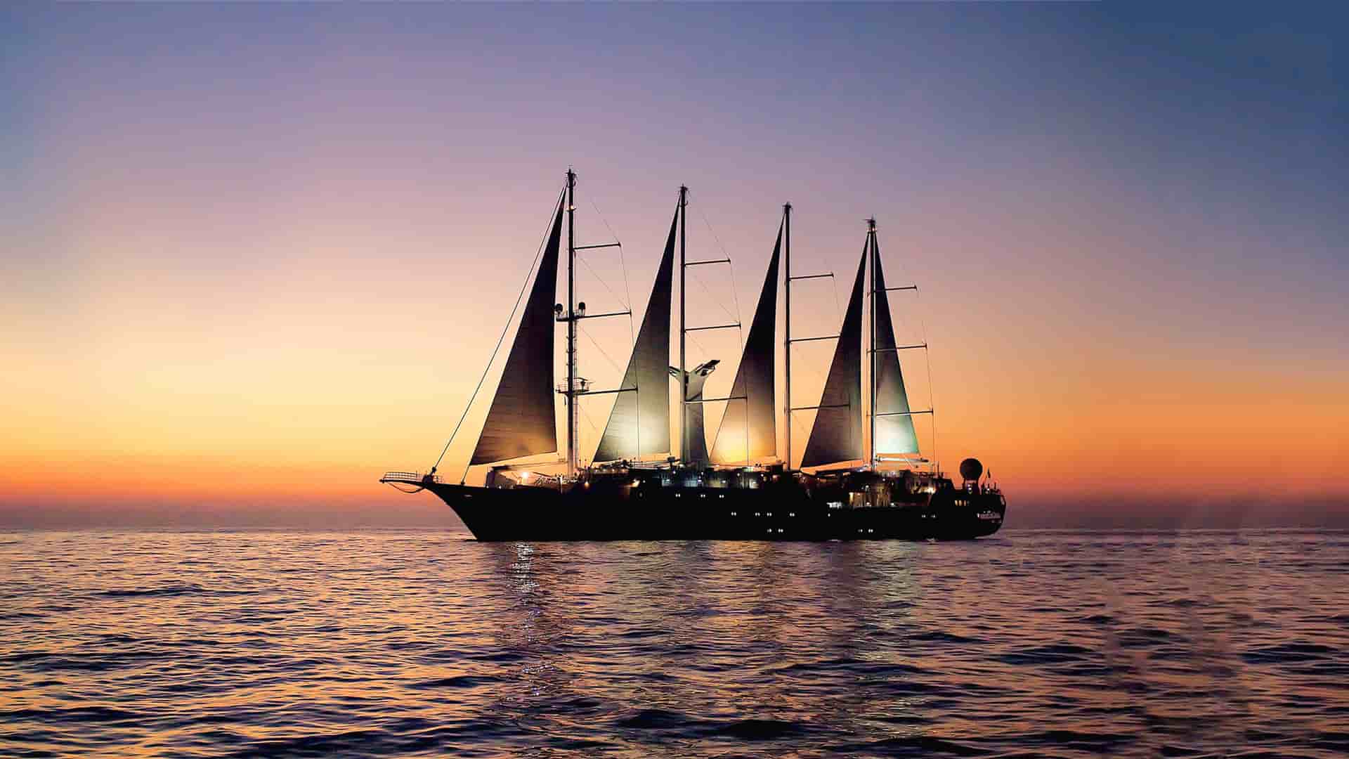 Windstar's Wind Star sailing yacht sailing at sunset.