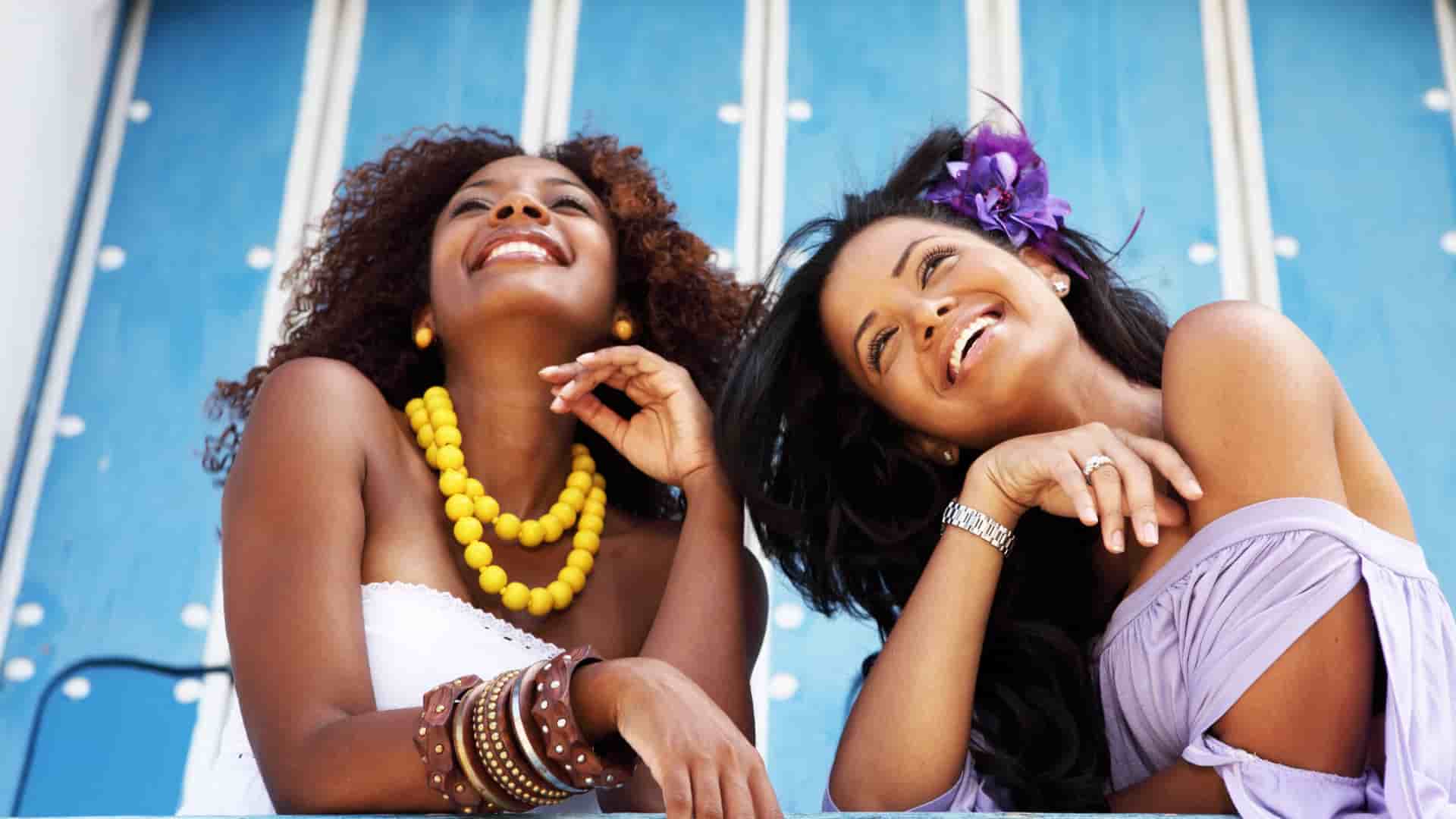 Women smiling on the beach in the Caribbean.