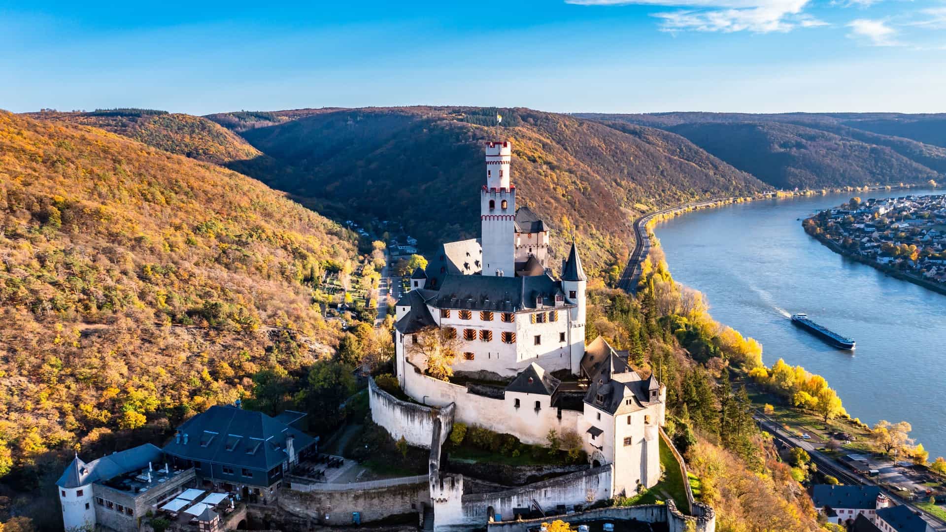 Rheinstein Castle overlooking Germany's Rhine River with autumn foliage, showcasing scenic beauty and historical charm on Avalon Waterways cruises.