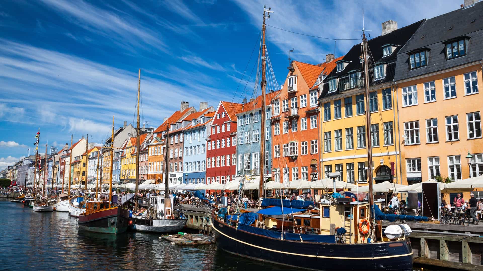 Vibrant Nyhavn harbor in Copenhagen, Denmark, a charming Northern European city with colorful historic buildings and traditional sailing ships, often visited on an Avalon Waterways cruise.