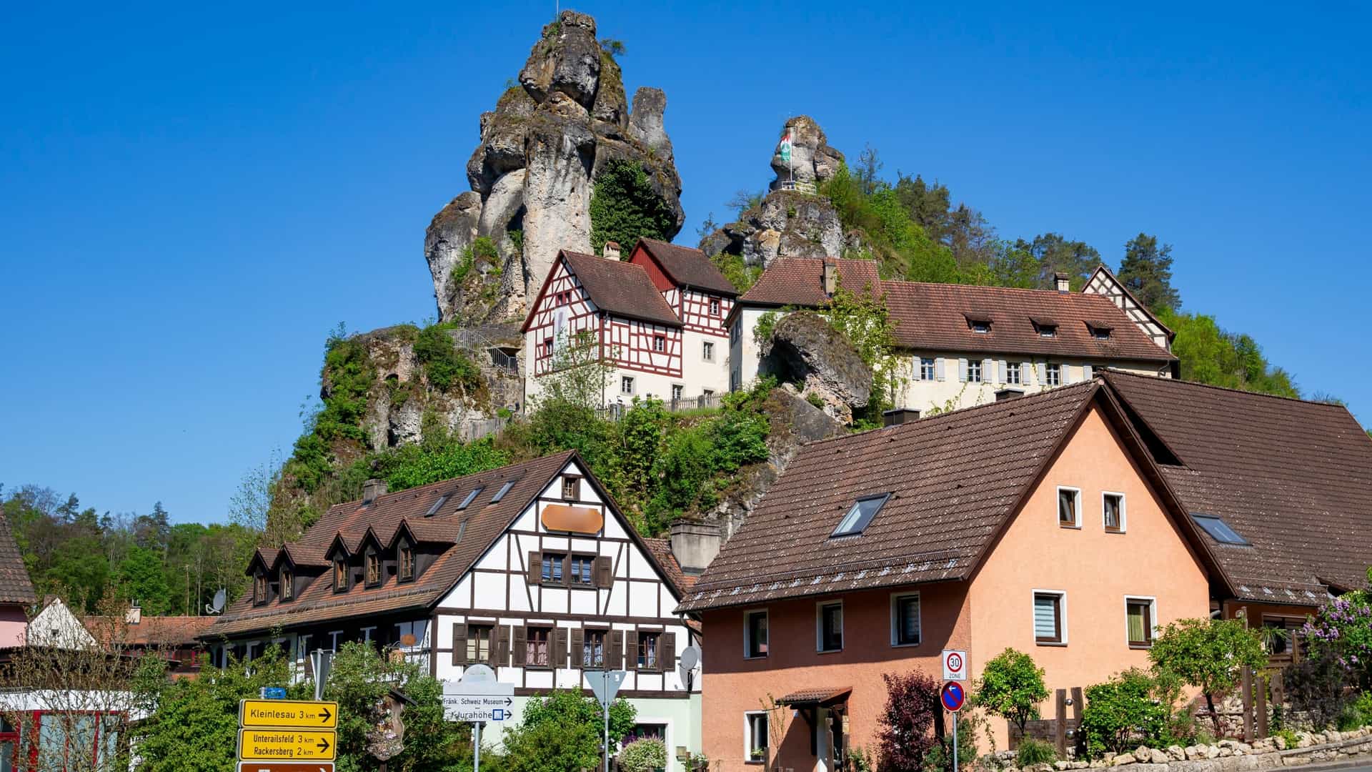 Towering limestone rocks and half-timbered houses in the picturesque village of Tüchersfeld, Bavaria, Germany.