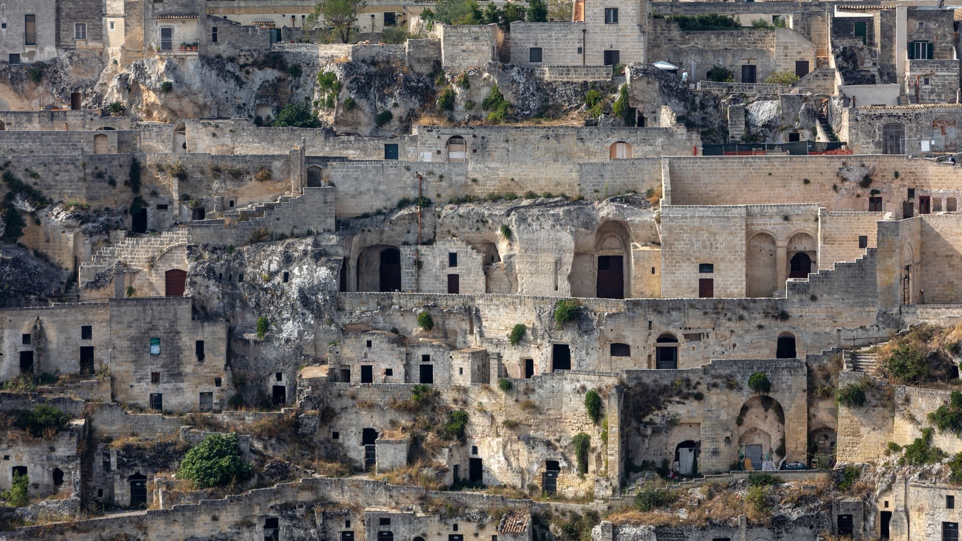 A panoramic view of the Sassi di Matera, a UNESCO World Heritage site in Italy, showcasing the ancient cave dwellings carved into the rock face.