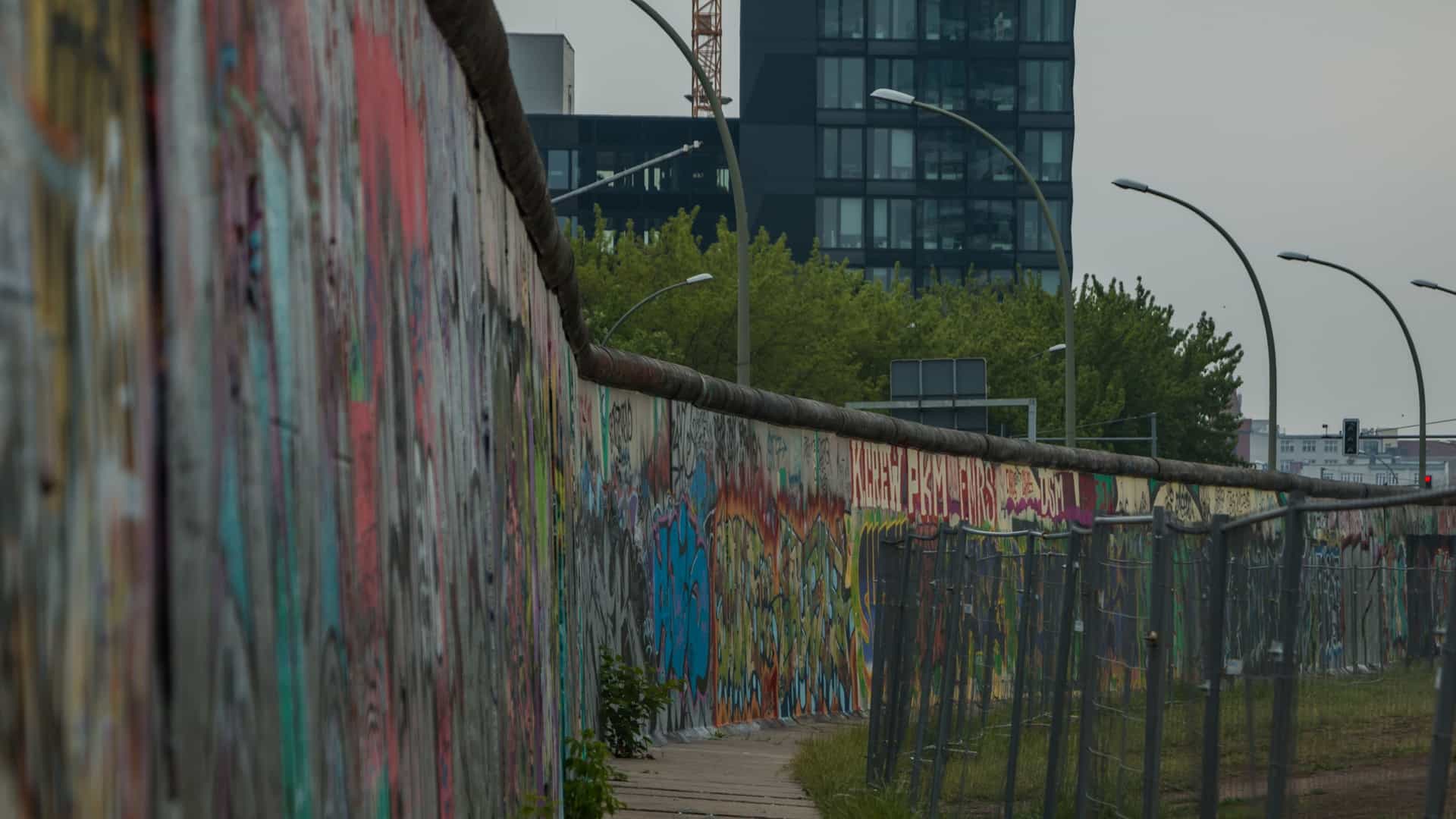  A section of the East Side Gallery in Berlin, the longest remaining part of the Berlin Wall, is covered in colorful murals. The artworks, painted by various international artists in 1990, are a testament to the peaceful reunification of Germany.