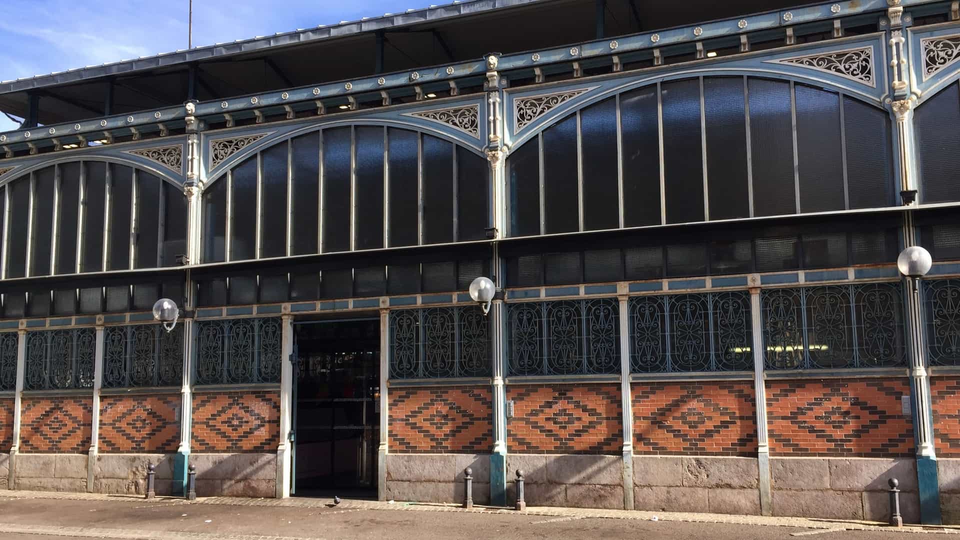  An architectural shot of the newly restored, covered Les Halles Centrales de Dijon market hall, a historic public building in France with detailed glass and ironwork.