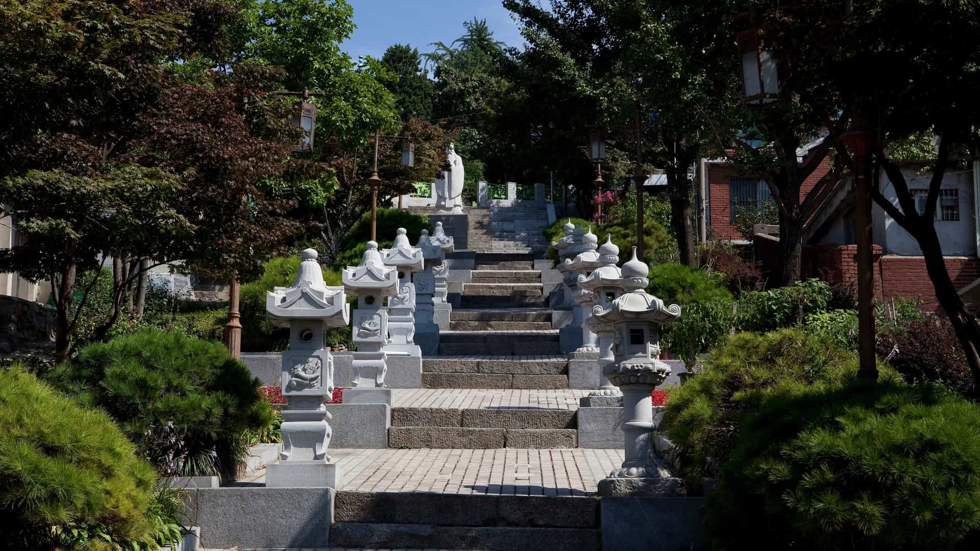 A street view of Incheon Chinatown, South Korea, featuring traditional Chinese-style architecture, red and gold decorations, and brightly colored street banners or signs, capturing the vibrant cultural atmosphere of the district.
