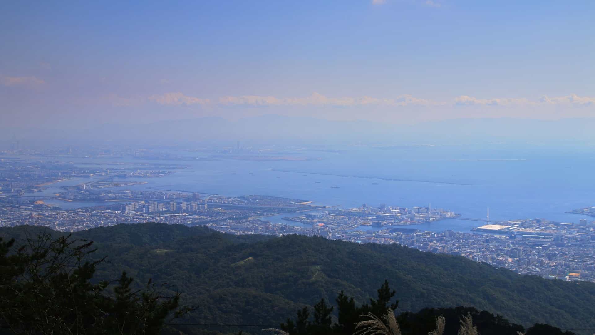  A high angle, panoramic view of the city of Kobe, Japan, and the surrounding Hyogo Prefecture at night, as seen from the top of Mount Rokko. The cityscape is illuminated by countless lights, creating a spectacular and widely acclaimed "10 Million Dollar Night View."