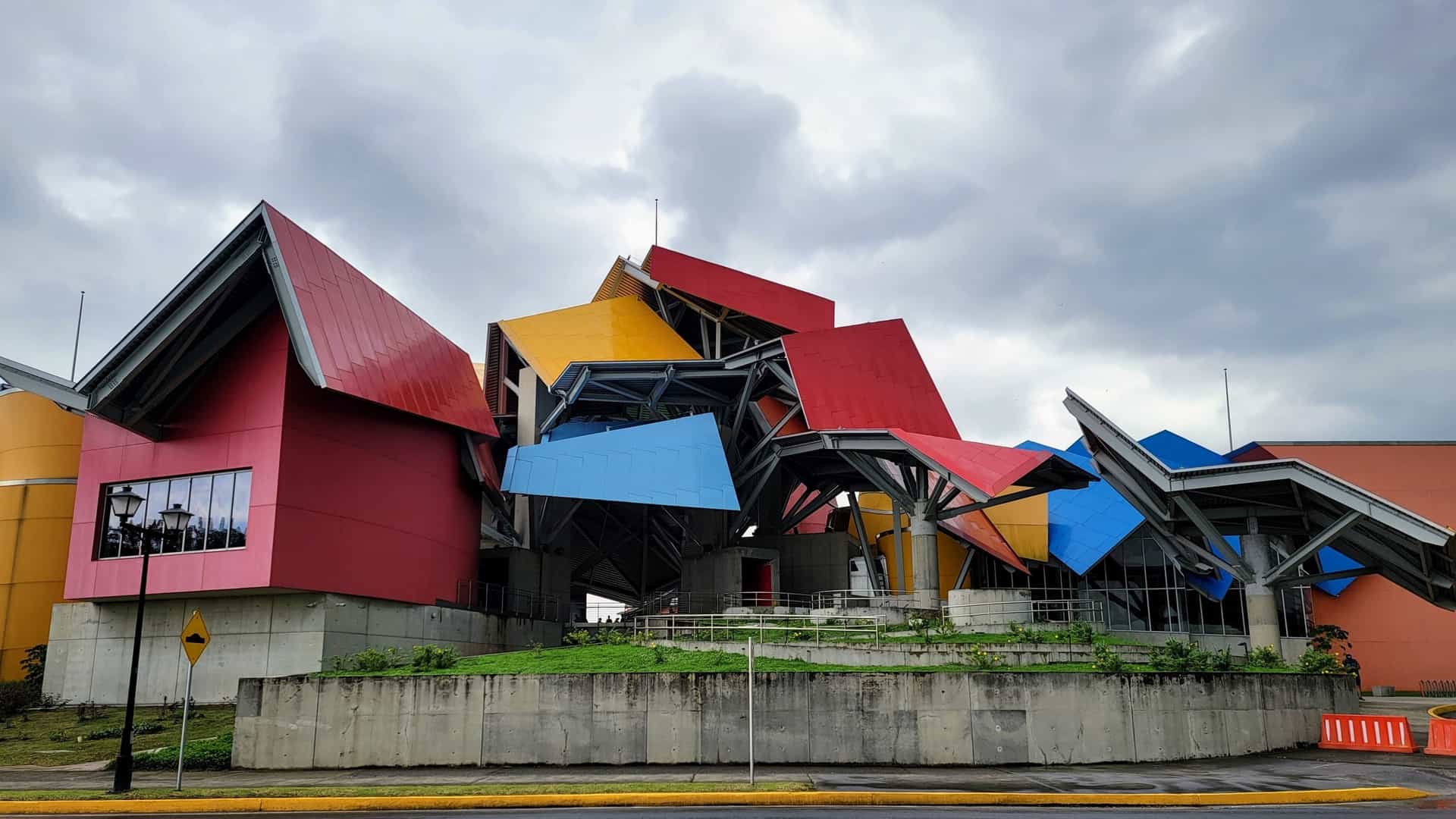 The Biomuseo in Panama City, Panama, a museum designed by architect Frank Gehry, featuring a complex, sculptural roof made of large, fragmented metal canopies in vibrant primary colors (red, yellow, and blue) set above a concrete base.