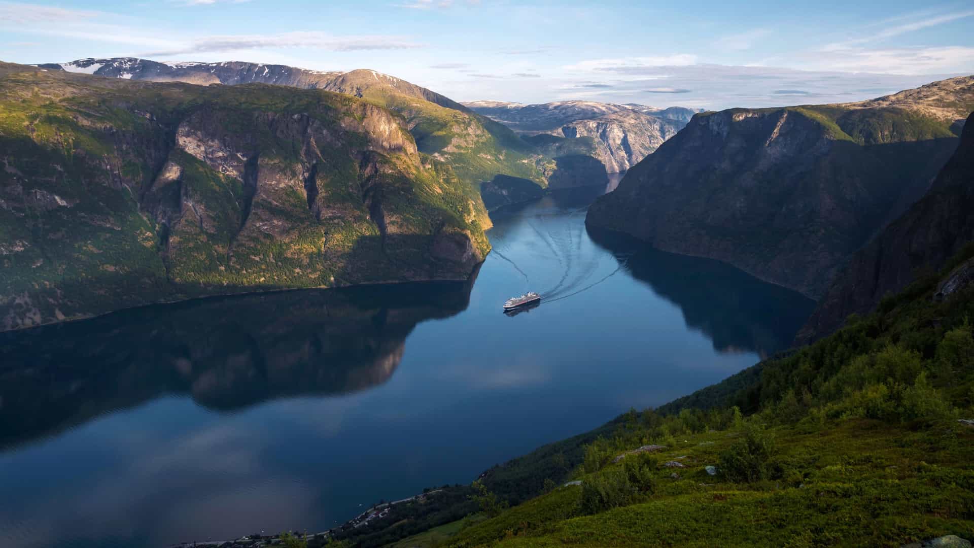 A mid-sized Holland America ship sales through the Hardangerfjord in Norway.