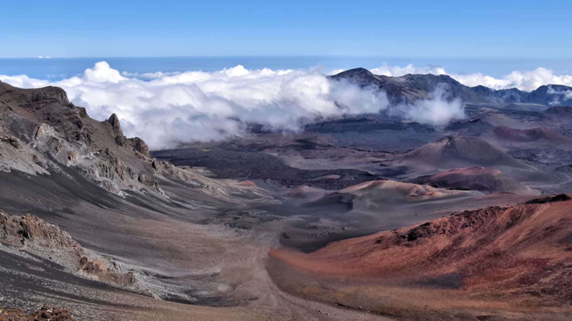 Wide shot of Haleakalā, or the East Maui Volcano, with clouds passing through.