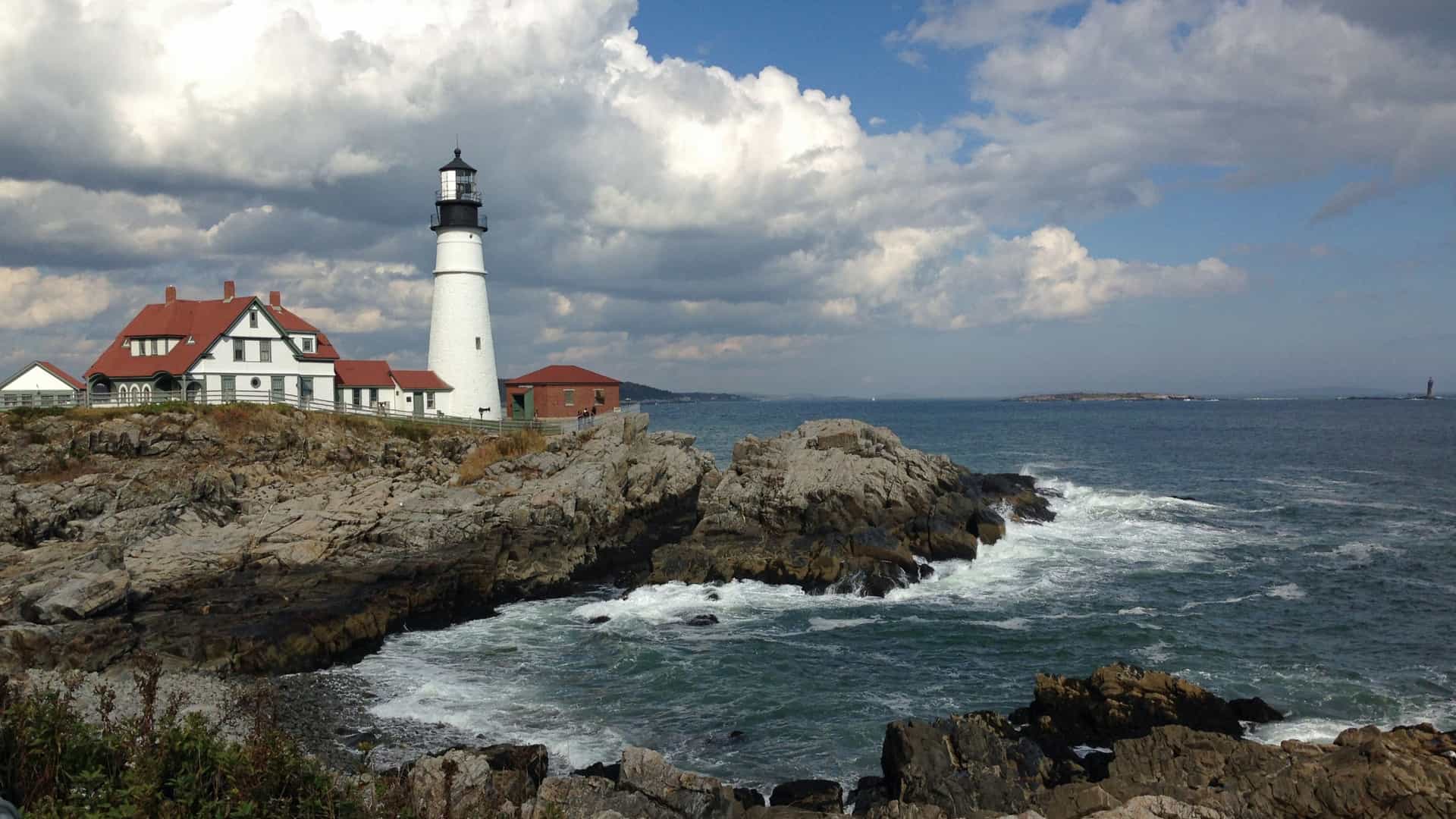 The historic Portland Head Light lighthouse sitting on a head of land at the entrance of the primary shipping channel into Portland Harbor.