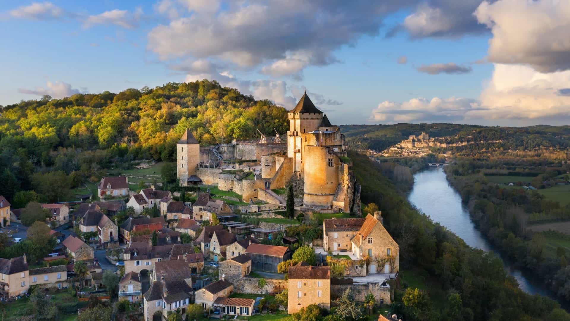Medieval Château de Castelnaud-la-Chapelle fortress overlooking a village and the Dordogne River valley in France.