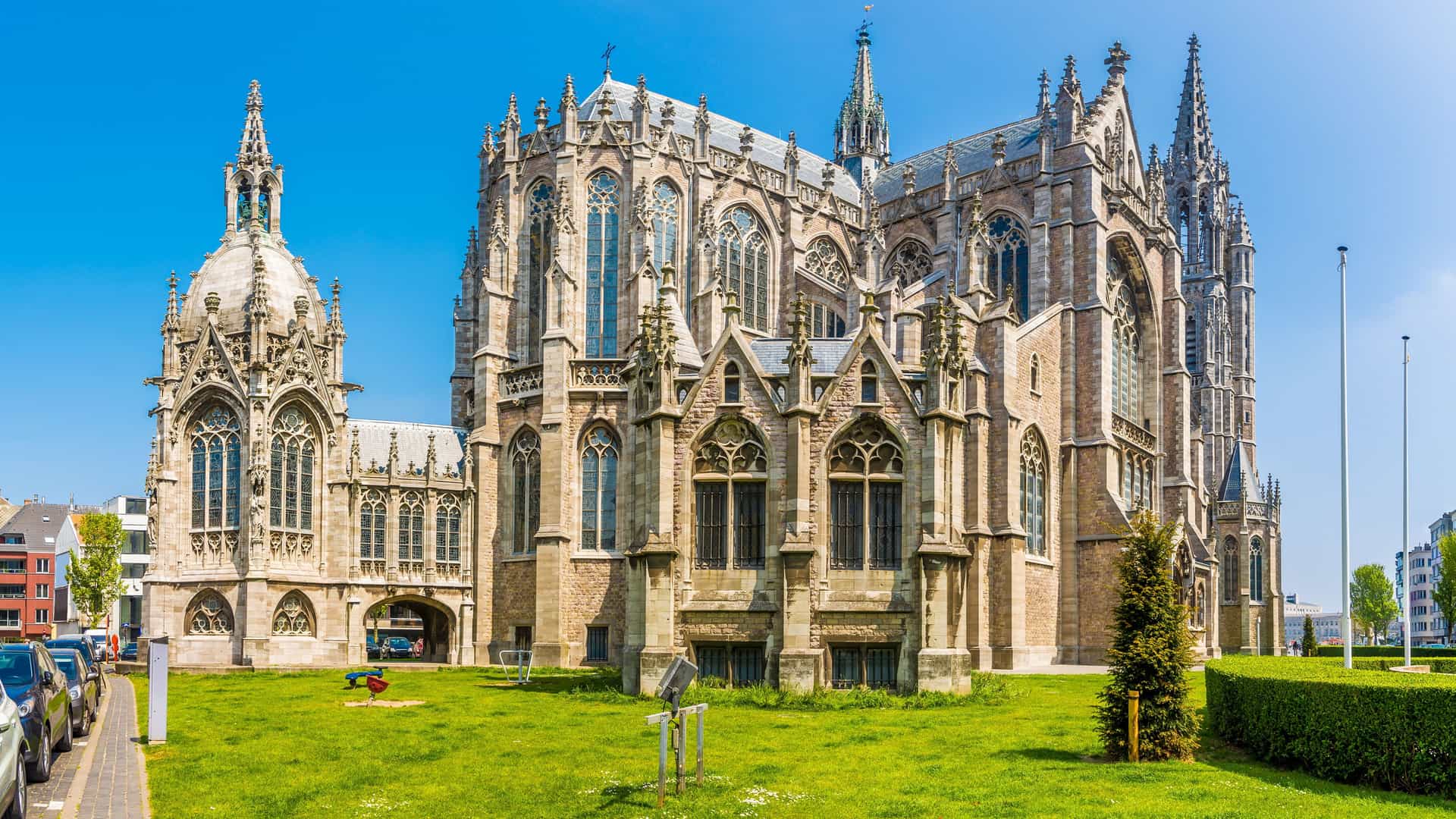 "A stunning wide-angle shot of the historic neo-gothic Saint Peter and Saint Paul Church, a major landmark in Ostend, Belgium, under a clear blue sky.  "