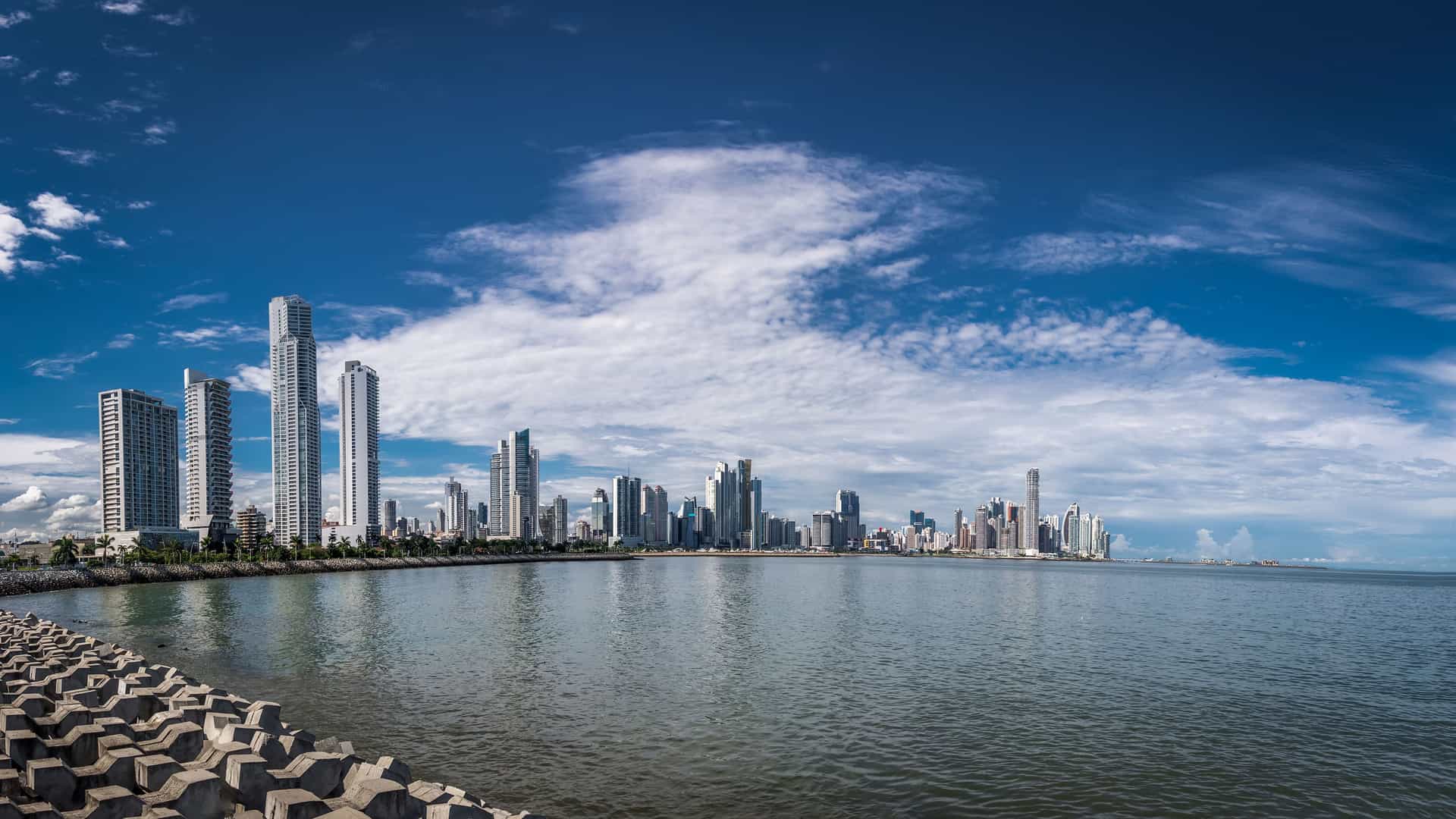 "A scenic panoramic view of the Panama City skyline on the Pacific Coast, with its modern skyscrapers and financial district reflected in the calm waters of the Pacific Ocean.  "
