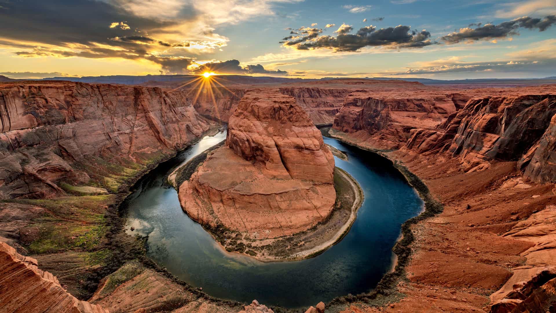 "A wide-angle landscape shot of the scenic Horseshoe Bend, a U-shaped meander of the Colorado River, in Page, Arizona, at sunset.  "