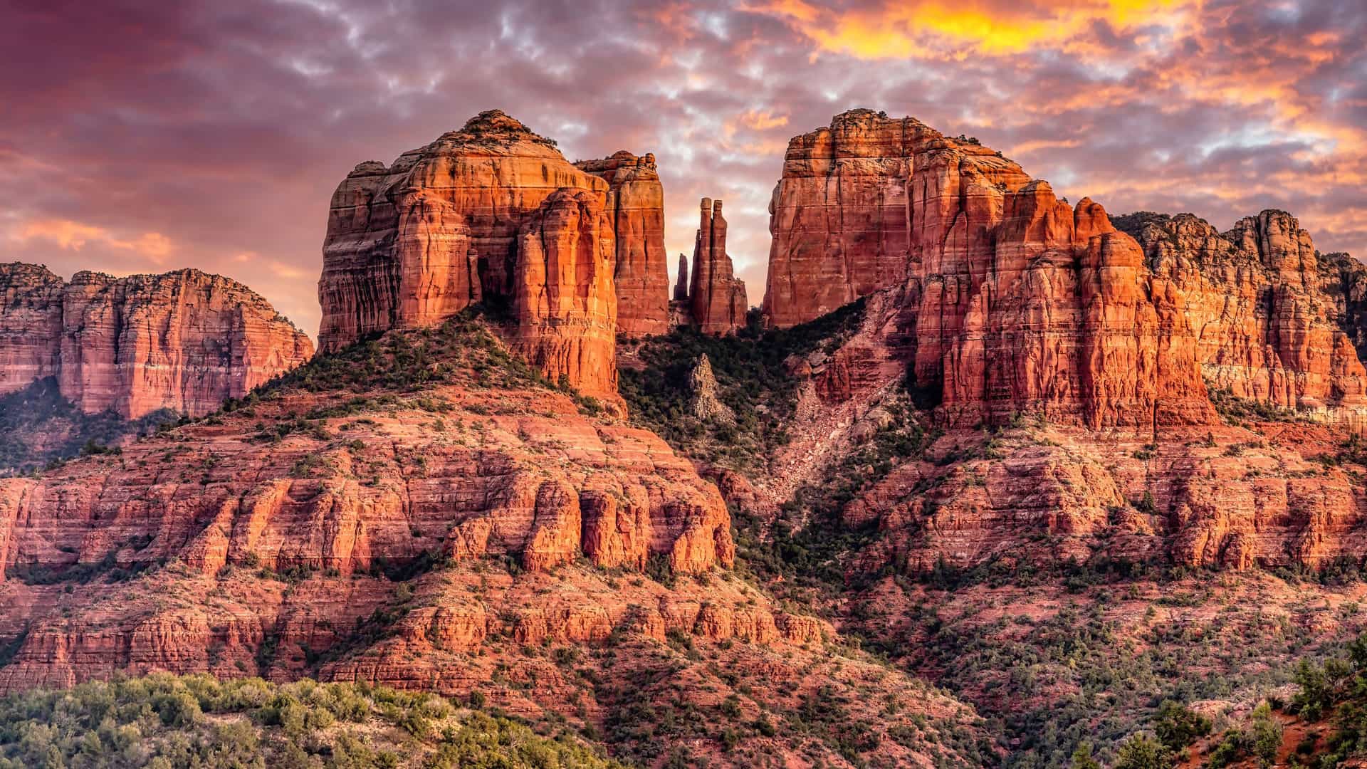 "A beautiful sunset over the dramatic red rock formations and iconic spires of the Sedona, Arizona desert landscape, with a colorful sky.  "