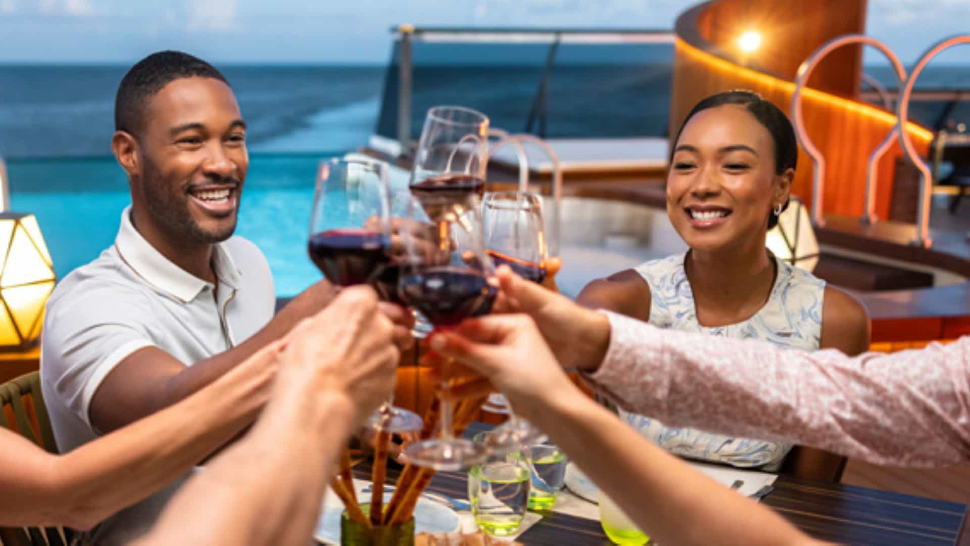 Guests toasting their wine glasses at the dinner table aboard a Seabourn expedition.
