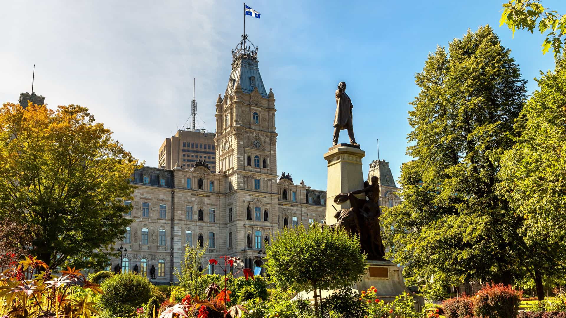 Historic stone architecture of the Parliament Building of Quebec surrounded by lush gardens on a Tauck Canada tour.