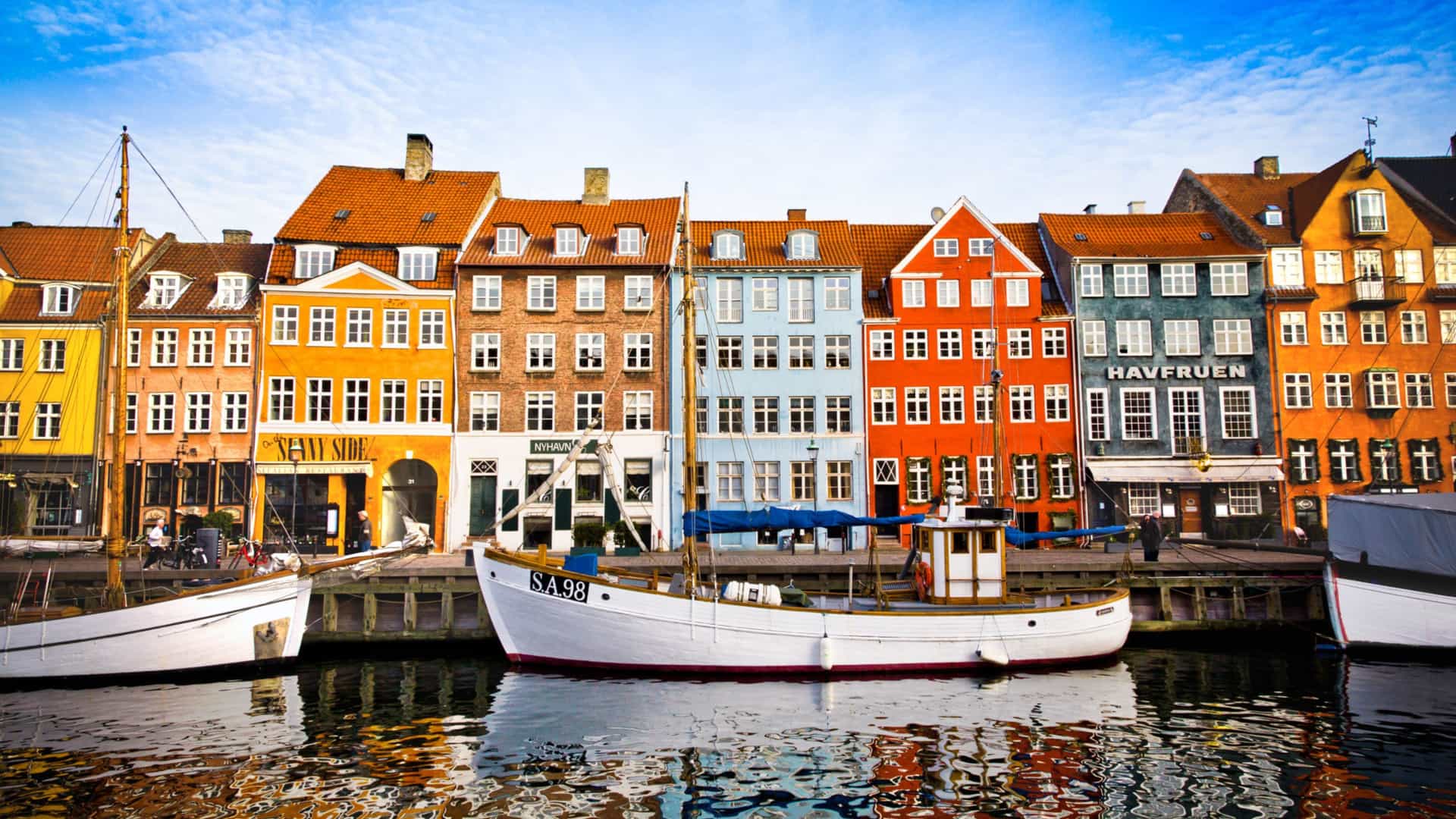 The vibrant and colorful Nyhavn harbor in Copenhagen, Denmark, a historic and picturesque destination on a Viking Ocean cruise to Northern Europe.