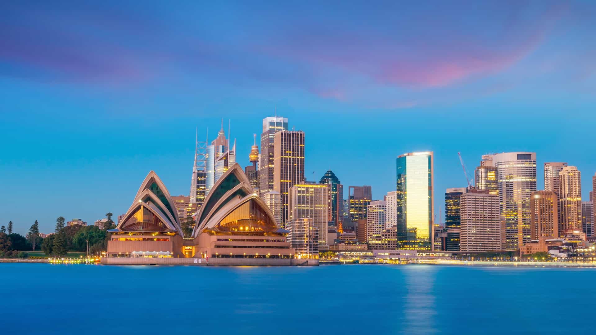 A beautiful view of the Sydney Opera House and city skyline at dusk, a memorable port of call on a Viking Ocean cruise to Australia.