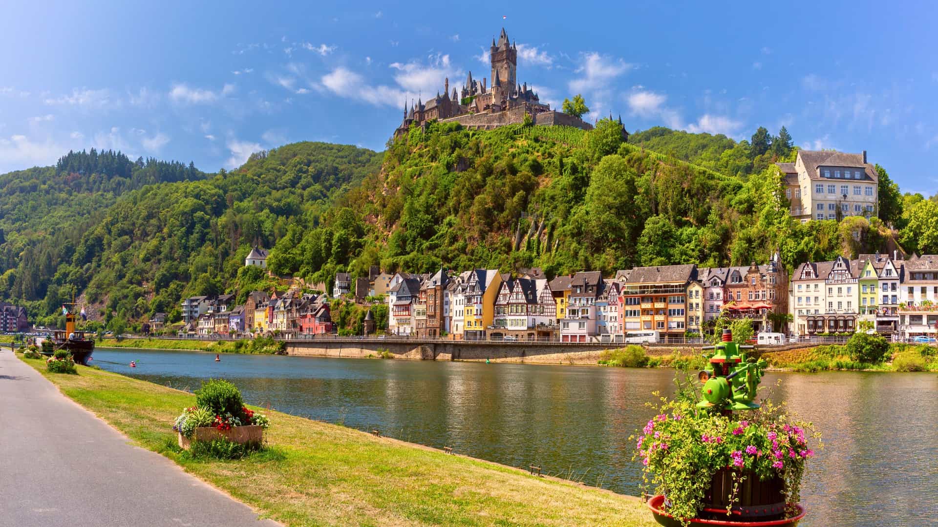 A scenic view of the town of Cochem and its majestic castle perched above the Moselle River in Germany, a picturesque stop on a Viking River cruise.