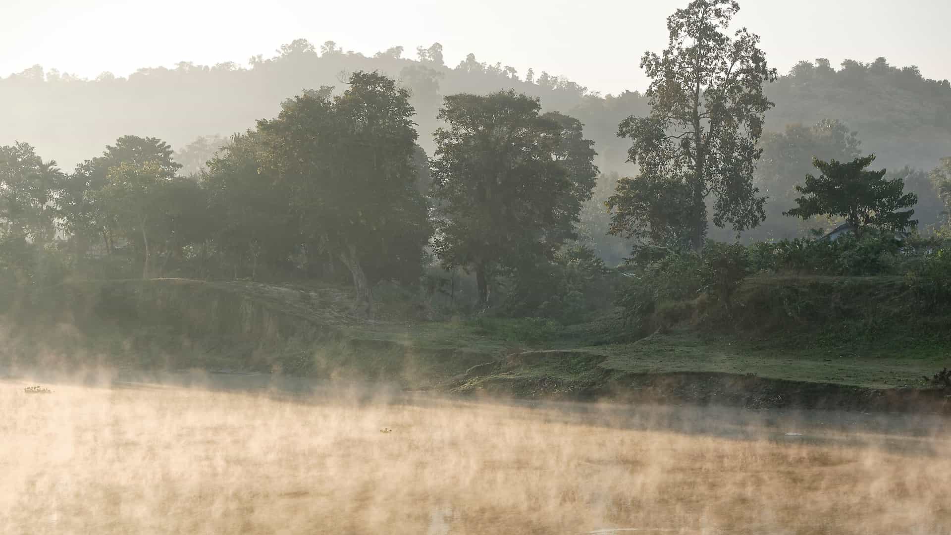Misty morning view of the river in Kaziranga, Assam, India, surrounded by lush greenery—an immersive nature experience on Viking River Cruises' India itinerary.