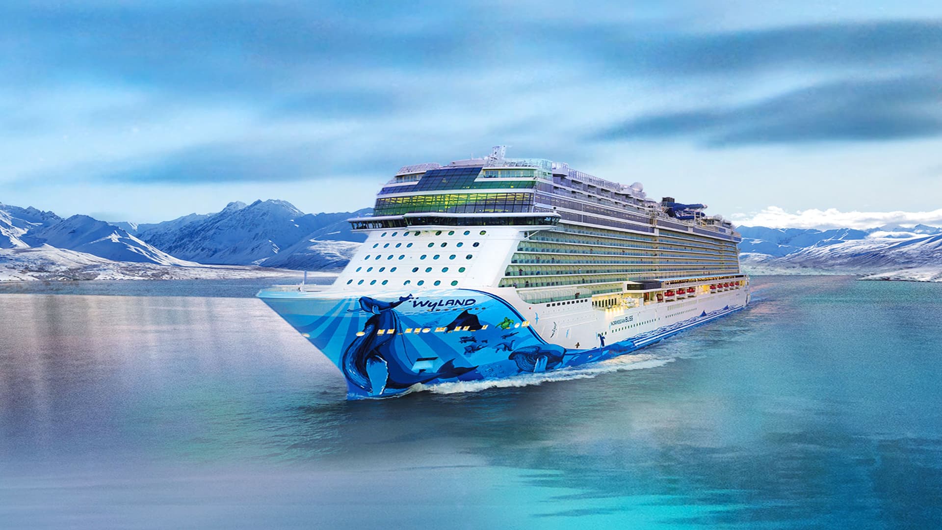 Norwegian Bliss sailing in Alaska with mountains behind her.