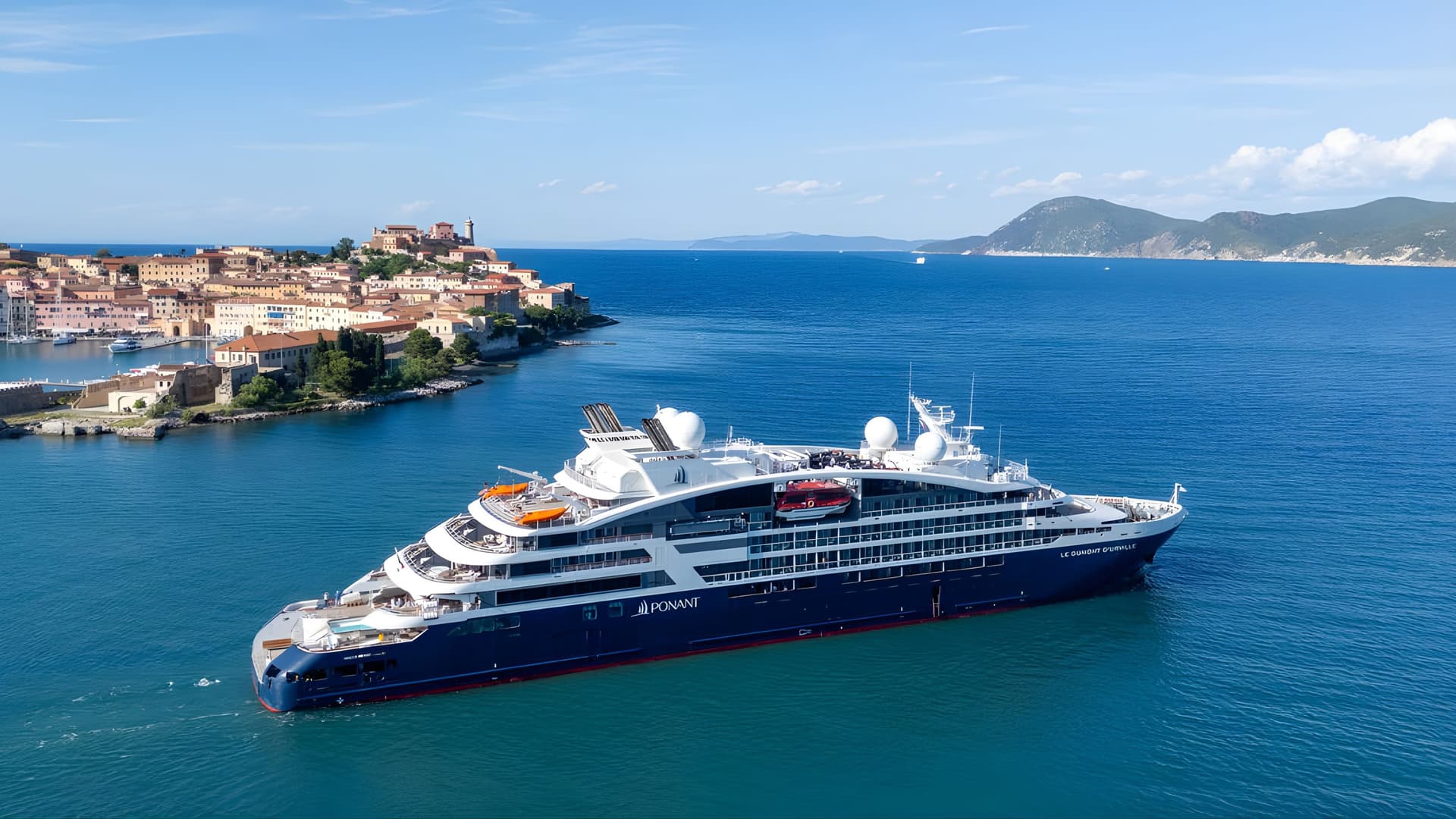 Tauck Ponant cruise ship Le Dumont D’Urville near Mediterranean coastal town