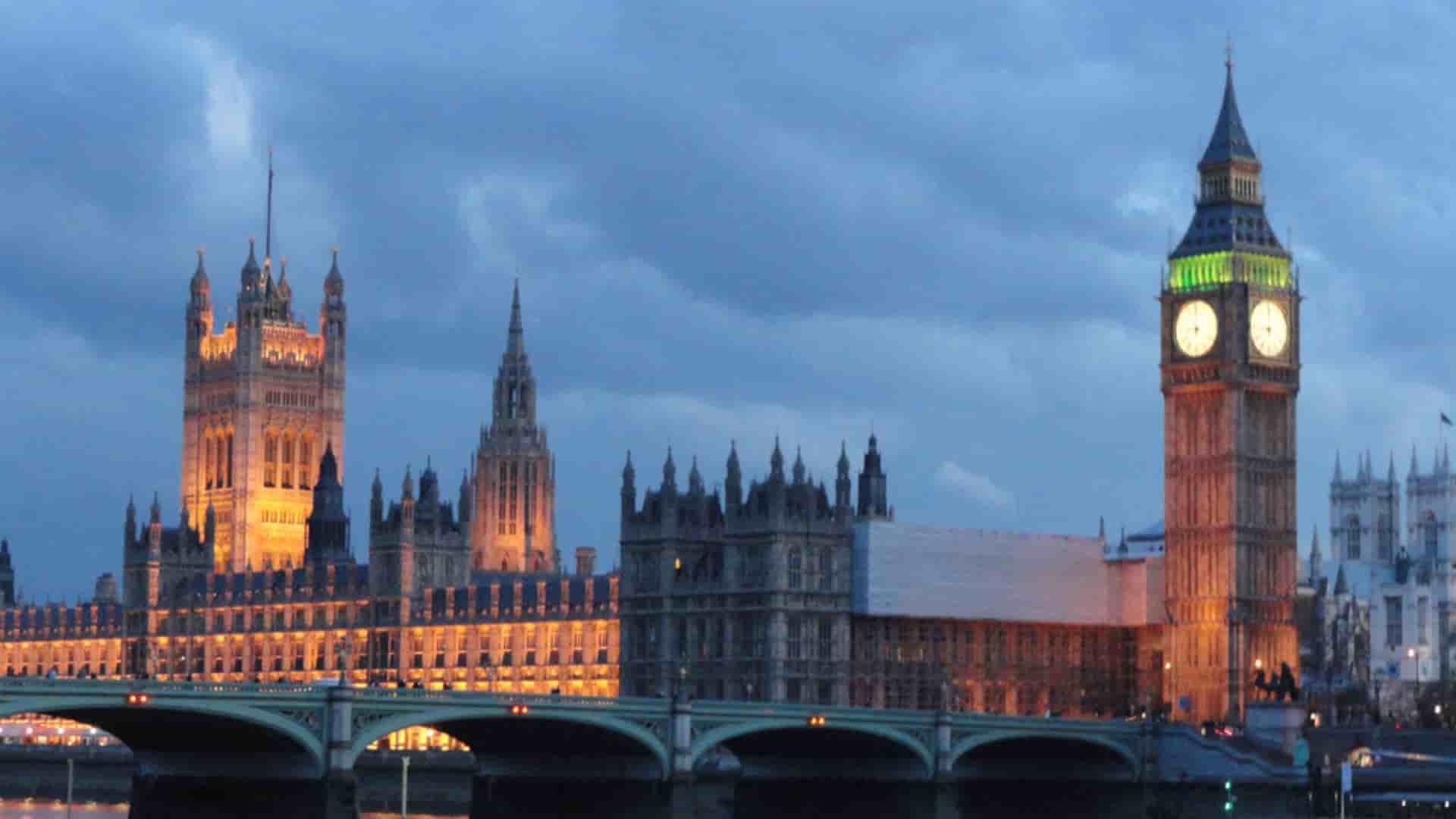 Avalon Waterways cruise extension to London, United Kingdom, with a view of the illuminated Houses of Parliament and the iconic Big Ben clock tower at night from the River Thames.