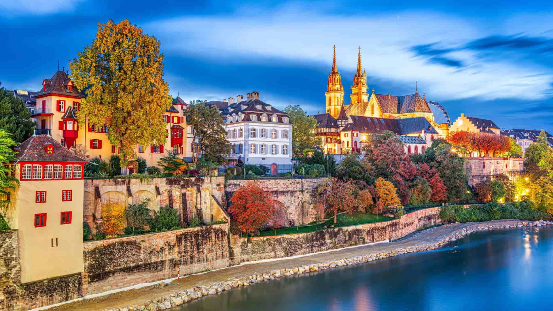 Picturesque European river town along the Rhine, with a towering church steeple and colorful autumn trees lining the riverbank, a charming scene experienced on an Avalon Waterways river cruise.