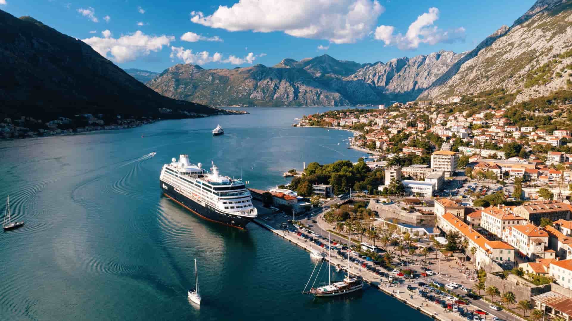 An Azamara ship docked in the stunning Bay of Kotor, Montenegro, a popular Mediterranean cruise destination.