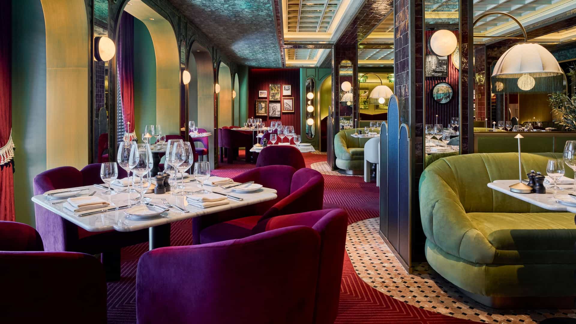 Elegant dining room interior of Trattoria Rossa featuring plush purple chairs, green velvet booths and ambient lighting.