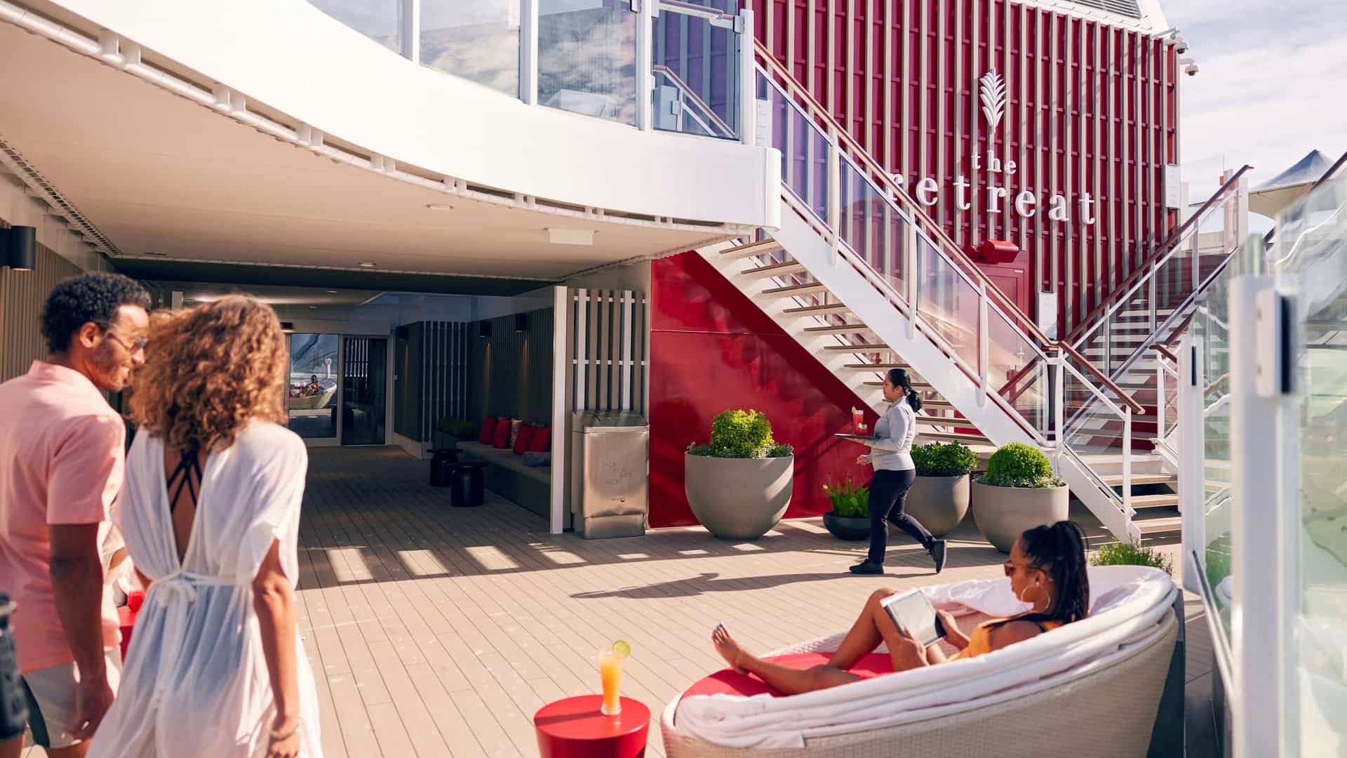 Couple walking past The Retreat on a Celebrity cruise ship.