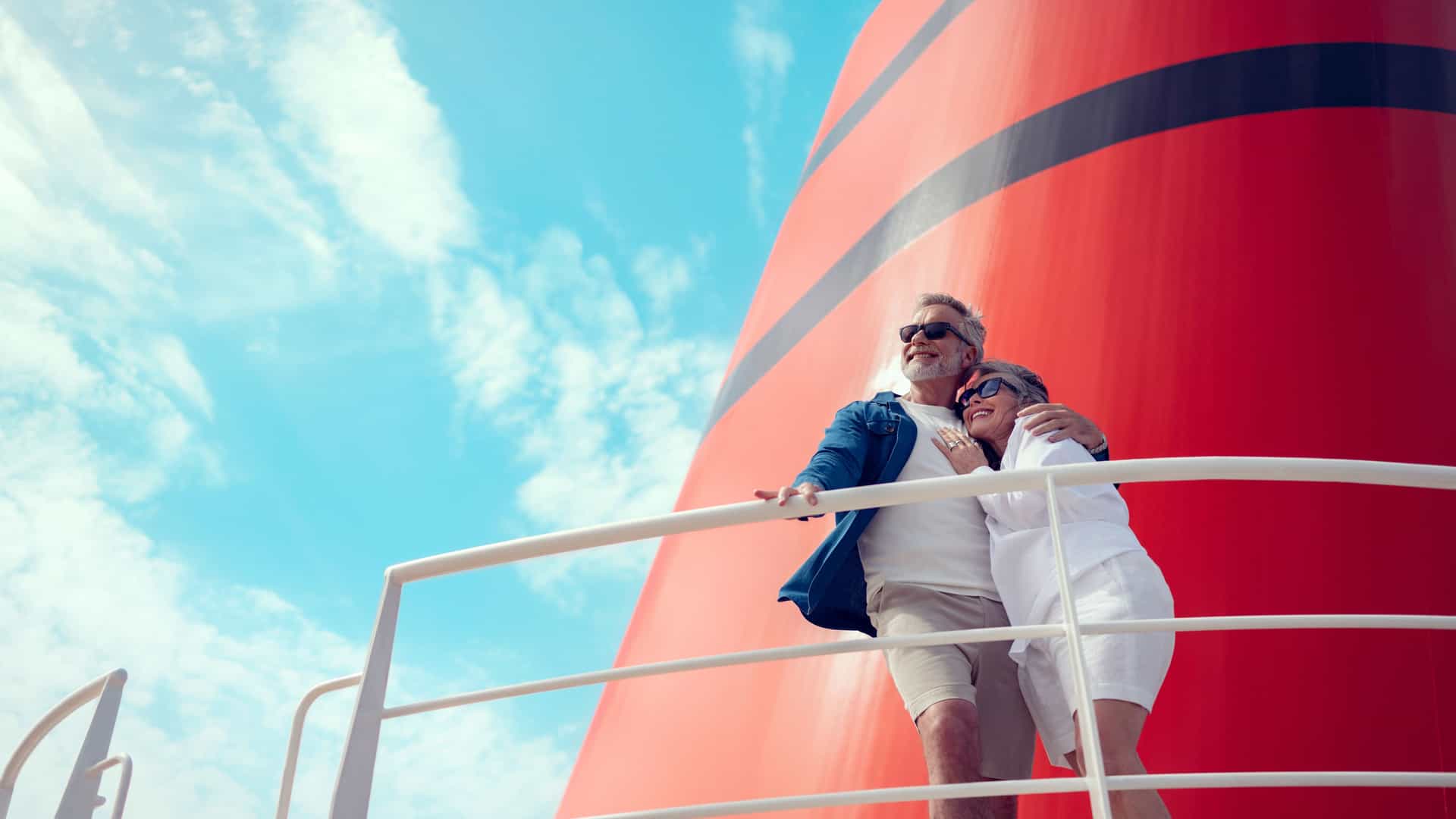 A couple enjoying the view together on the deck of a Cunard cruise ship.