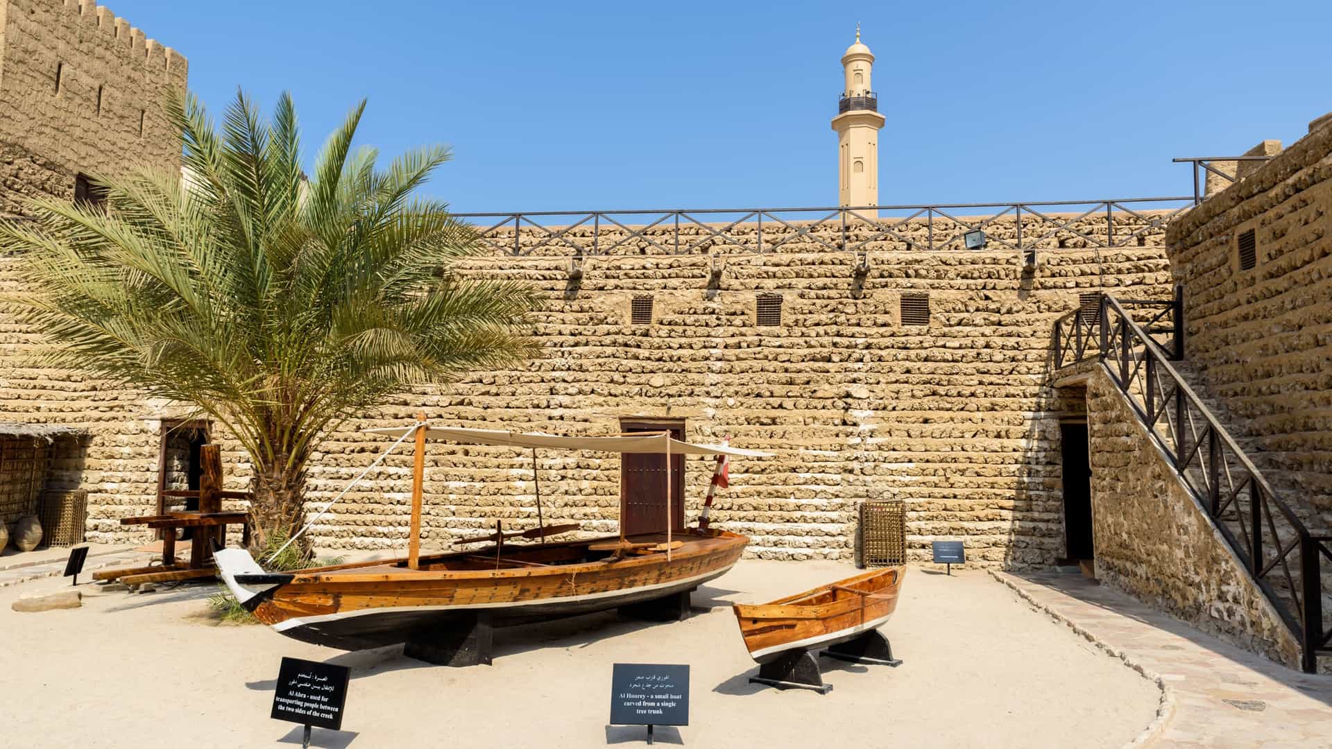 photo of the Dubai Museum, housed in the historic Al Fahidi Fort in Dubai, United Arab Emirates. The view shows the traditional, thick walled stone fort structure, typically with square towers and a wooden entrance gate.