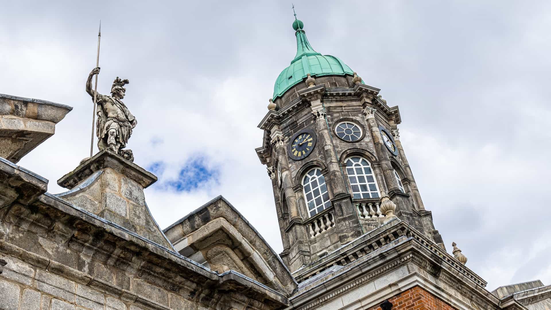 A photograph of Dublin Castle in Dublin, Ireland. The image likely shows the architectural features of the castle, which is a mix of medieval and Georgian styles. Key elements visible may include the Chapel Royal and the Record Tower, with other buildings of the complex surrounding a courtyard. The scene is of a historical landmark, possibly with a clear sky and tourists.