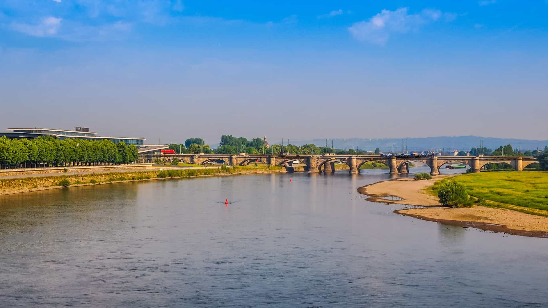 A scenic Elbe river with a bridge crossing over it.