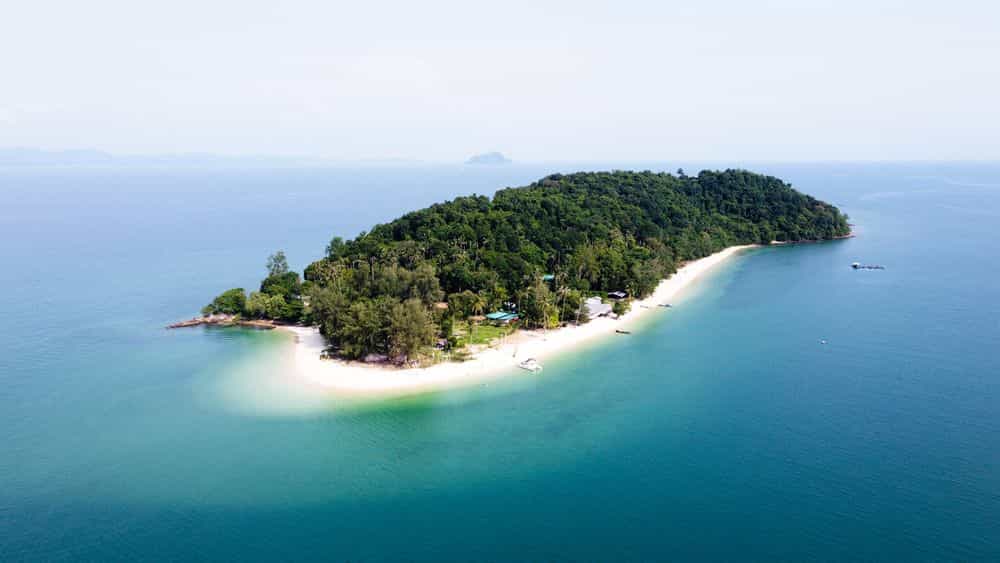 Drone view of Koh Naka Noi Island near Phuket, Thailand, showcasing turquoise waters, white sandy beaches, and lush tropical landscape