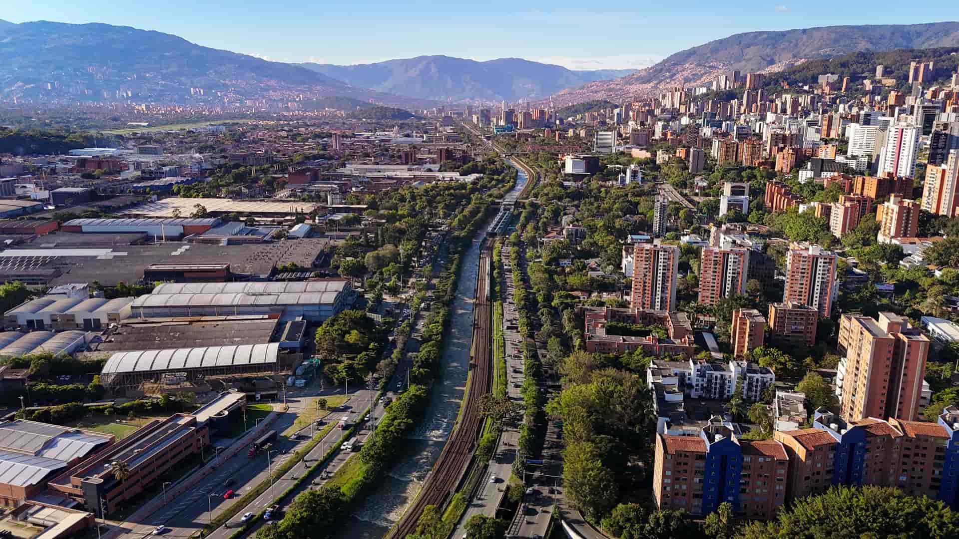 Aerial view of Medellín River and city with mountains in Colombia.