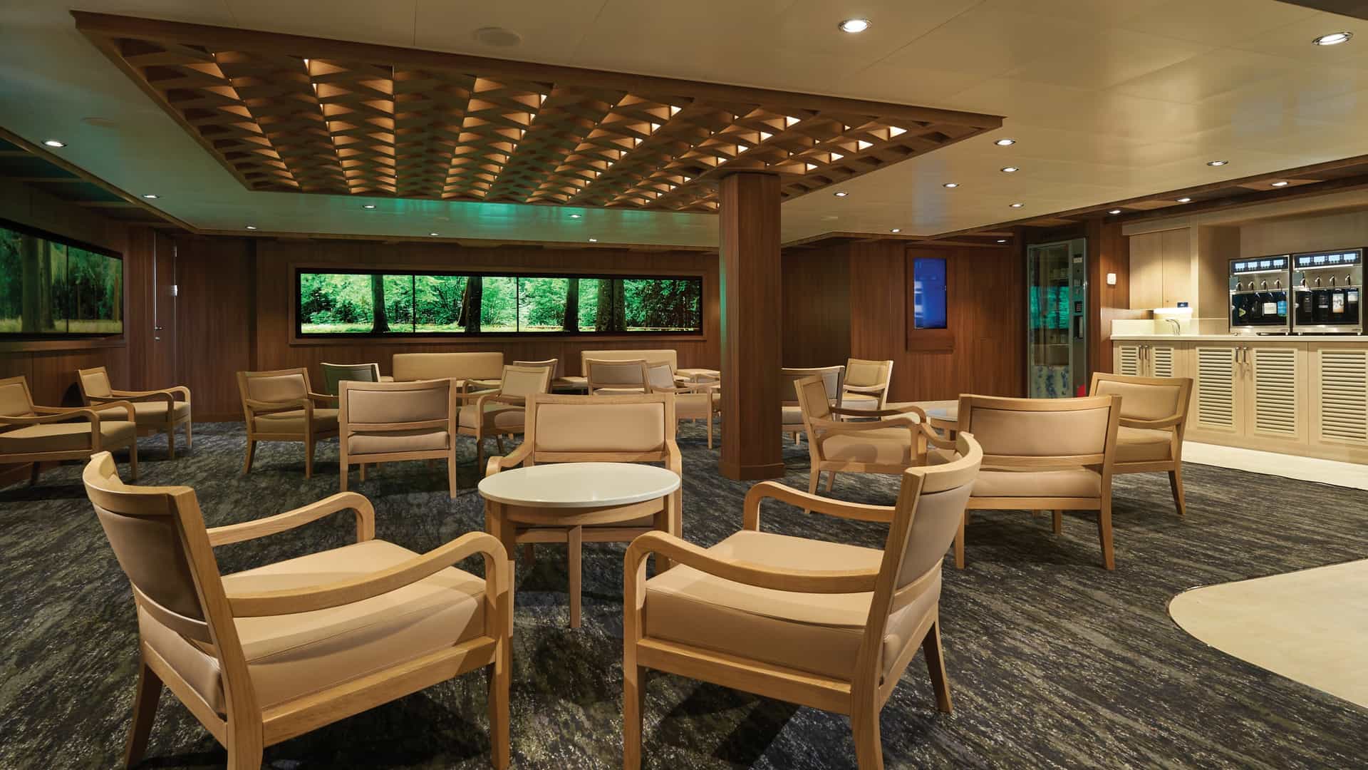 Studio Lounge on Norwegian Bliss with wood-framed armchairs, a lattice ceiling and wall screens showing a forest scene.