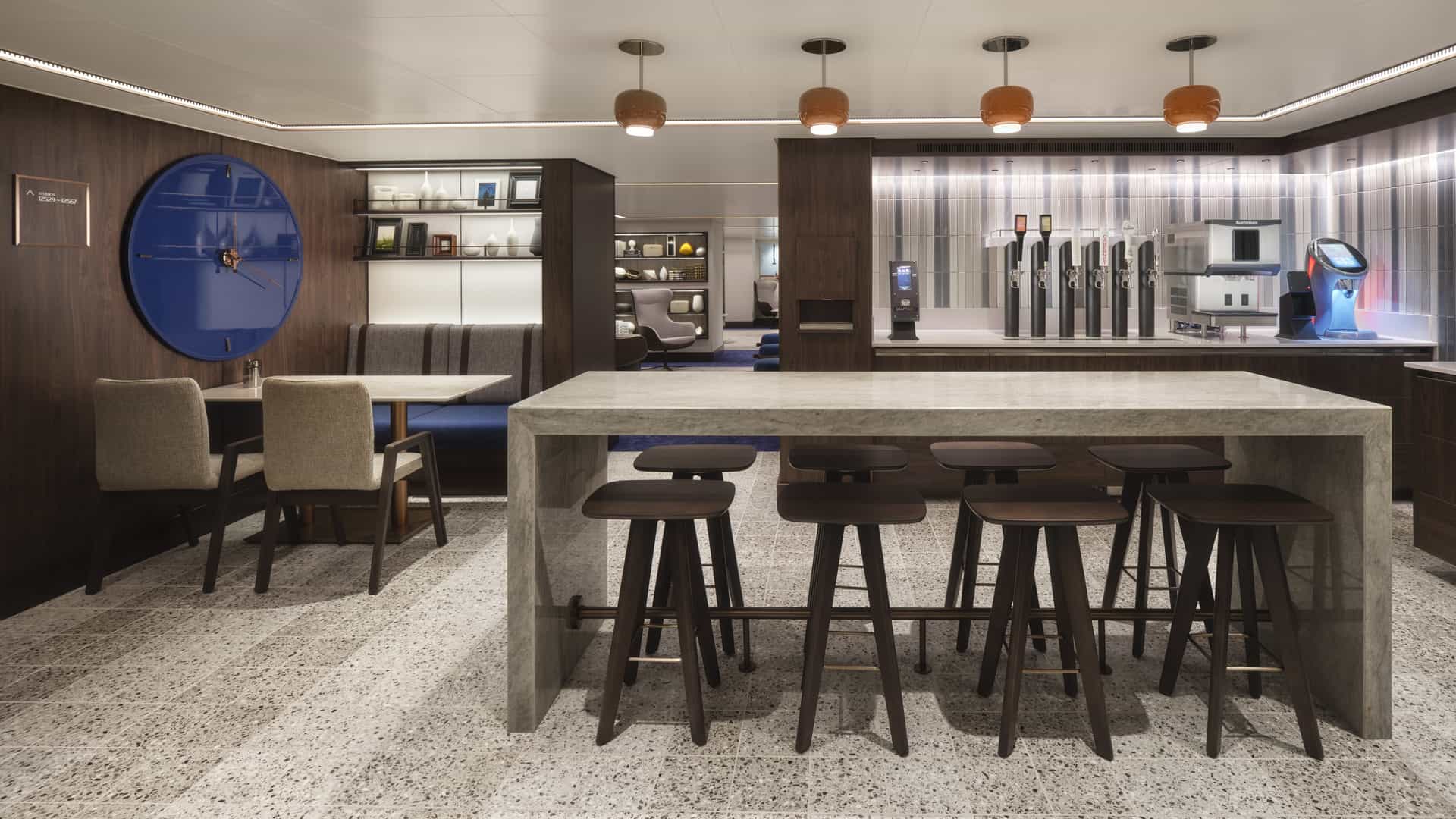 Studio Lounge counter area on Norwegian Prima with a shared stone table, bar stools and beverage taps.