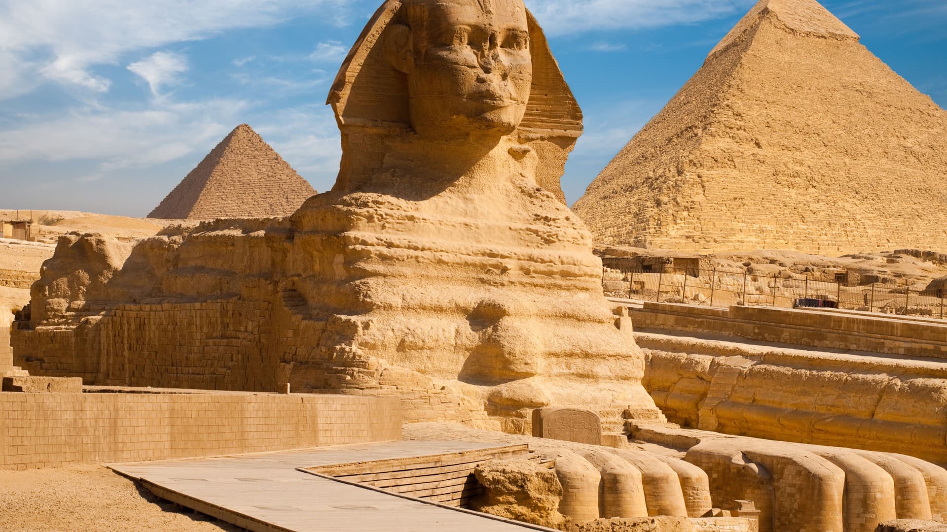 A magnificent view of the Great Sphinx of Giza with the Pyramid of Khafre and the Great Pyramid in the background, a historic landmark near Cairo, Egypt.