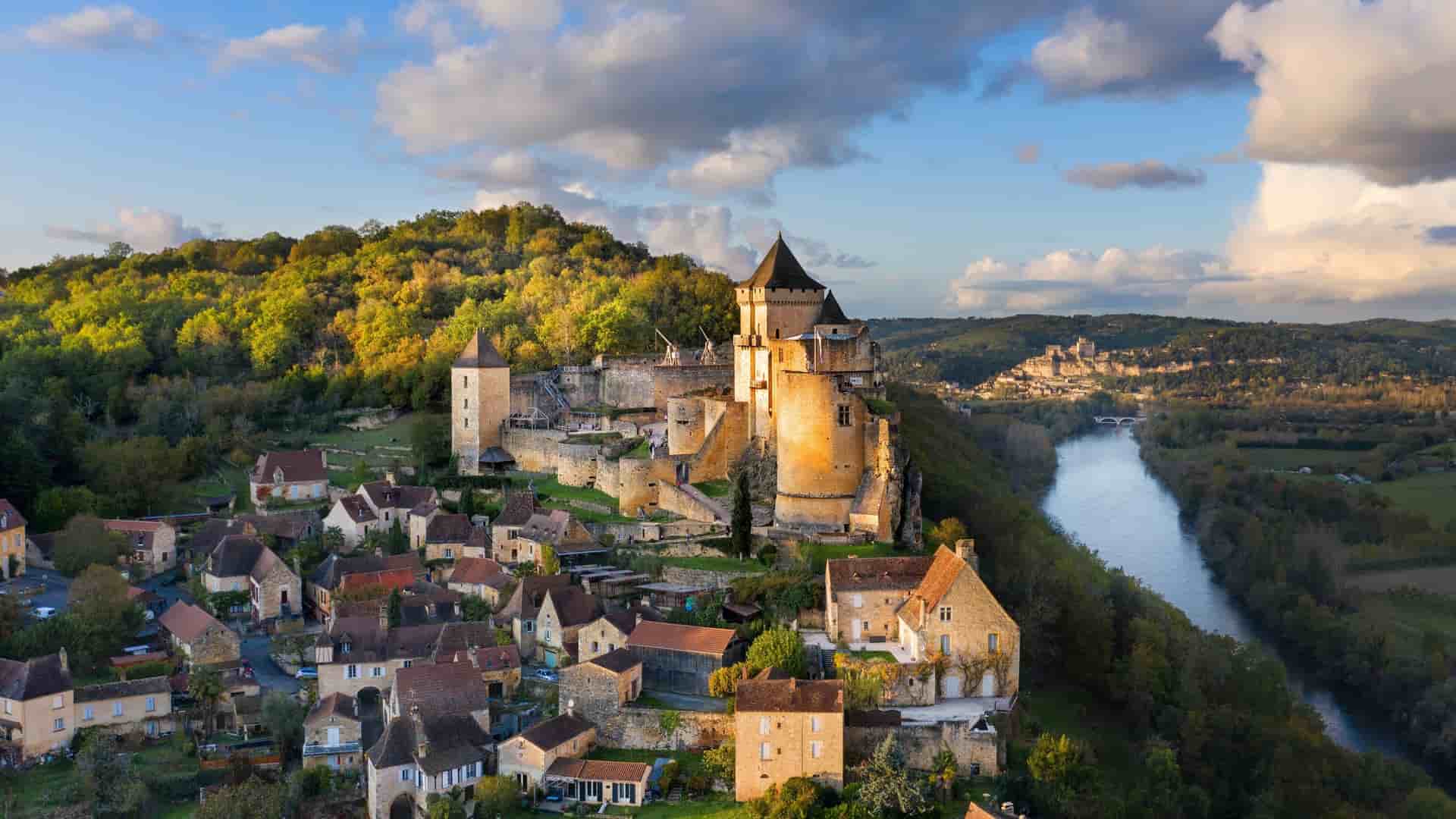Medieval Château de Castelnaud-la-Chapelle fortress overlooking a village and the Dordogne River valley in France.
