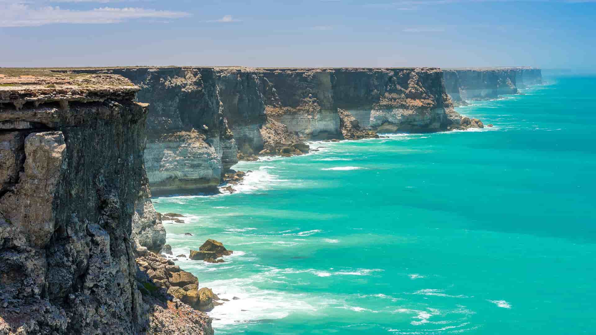 A dramatic scenic view of the Bunda Cliffs along the Great Australian Bight, showcasing the rugged coastline and the vibrant turquoise waters of the Southern Ocean.