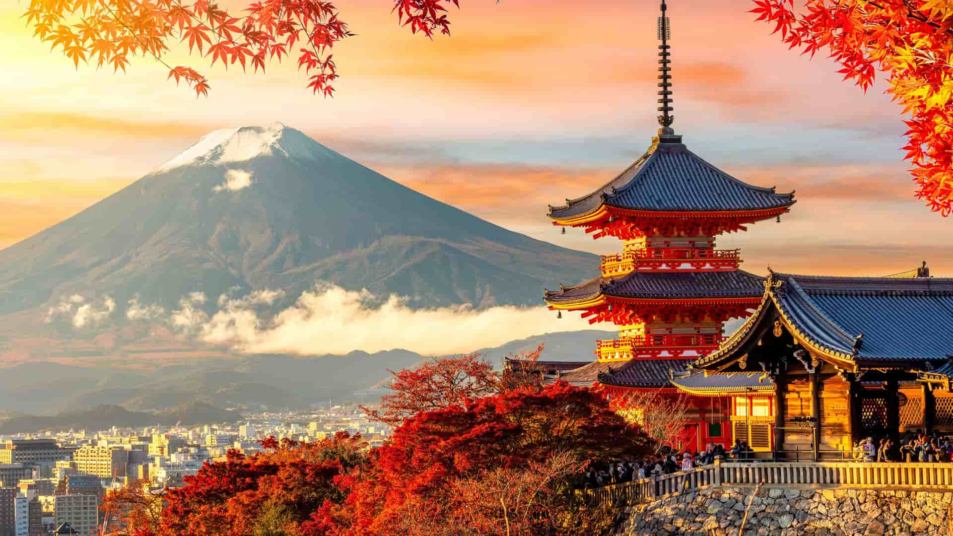"A scenic view of the iconic Mount Fuji with a snow-capped peak, framed by colorful autumn leaves, and the vibrant red Kiyomizu-dera Temple pagoda in the foreground in Kyoto, Japan. "