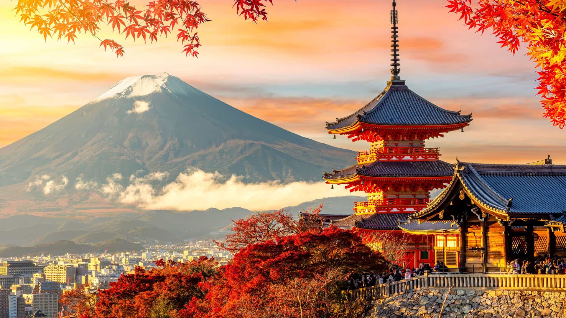 "A scenic view of the iconic Mount Fuji with a snow-capped peak, framed by colorful autumn leaves, and the vibrant red Kiyomizu-dera Temple pagoda in the foreground in Kyoto, Japan. "